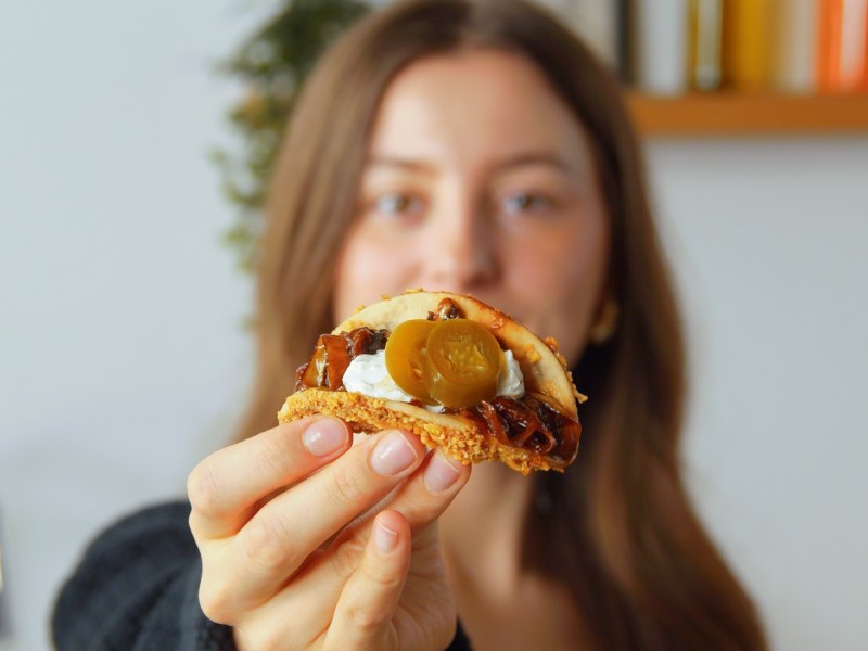 Una mujer sostiene un taco relleno de cáscaras de plátano.