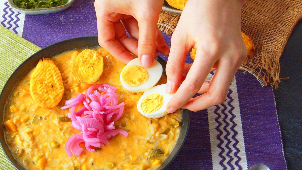 Fanesca servida en una olla de barro, con una cuchara al lado.
