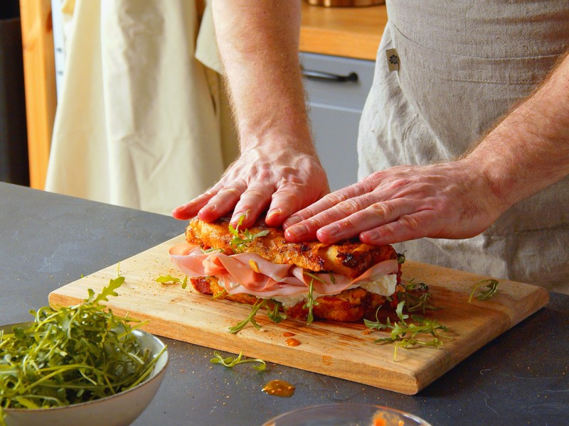 Un cocinero presenta un pan de pizza relleno cortado.