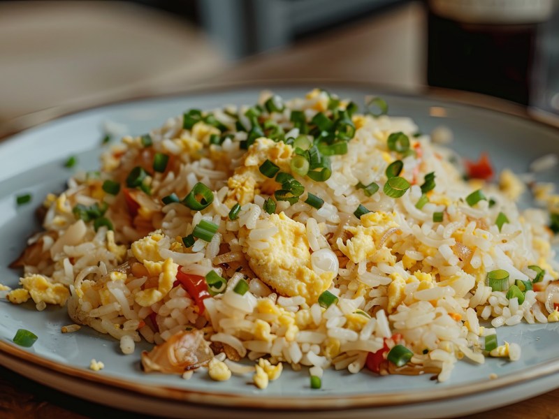 Plato con arroz frito con huevo y verduras.