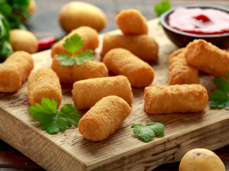 Croquetas de papa en una tabla.
