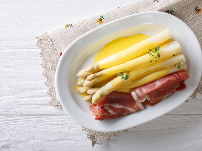 Plato con espárragos blancos, jamón y salsa de azafrán