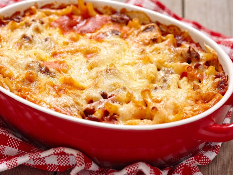 Macarrones al horno a la mamma en una fuente roja para horno.