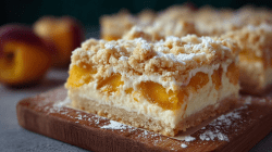 Un trozo de pastel de requesón y durazno en bandeja. Al fondo se ven duraznos enteros y el resto del pastel.